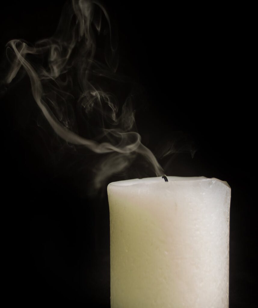 extinguished thick wax candle with smoke
